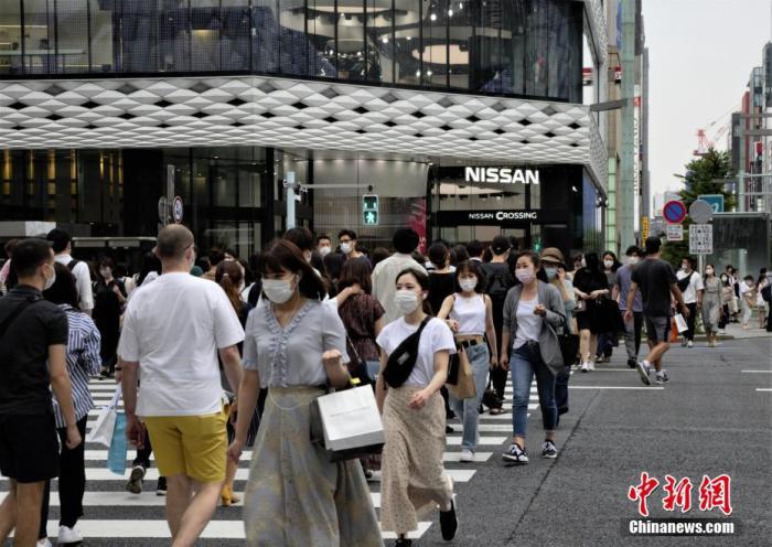 当地时间6月6日，日本东京都发布新冠肺炎疫情“东京警报”后的首个周末，当地选择出门逛街的民众数量并没有大幅减少。图为当地民众佩戴口罩走过东京街头。
/p中新社记者 吕少威 摄
