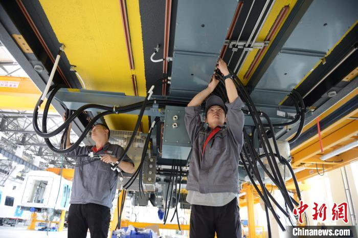 6月7日，工作人员检查地铁列车底部零部件。　刘文华 摄